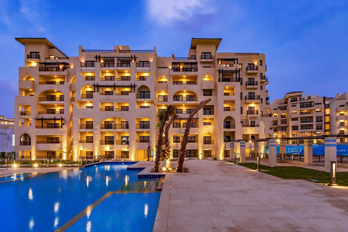 ALDAU Heights residential facade and outdoor pool after sunset